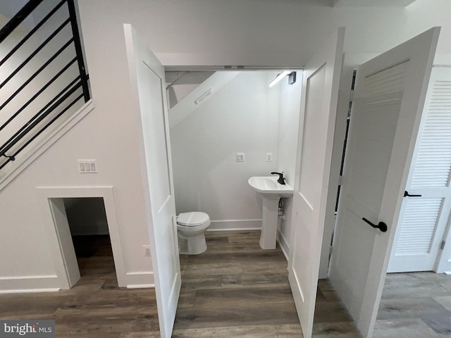 bathroom with hardwood / wood-style floors, toilet, and sink