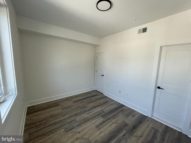 unfurnished room featuring dark wood-type flooring