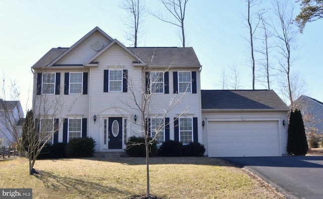 colonial-style house featuring a front lawn and a garage