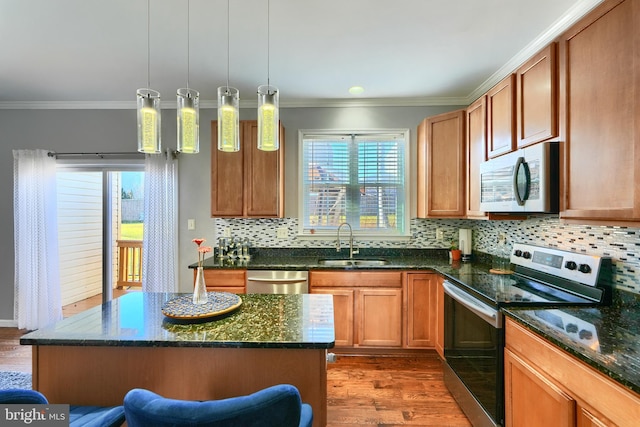 kitchen featuring appliances with stainless steel finishes, dark hardwood / wood-style flooring, sink, pendant lighting, and a center island