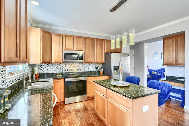 kitchen featuring a center island, sink, stainless steel appliances, light hardwood / wood-style flooring, and decorative light fixtures