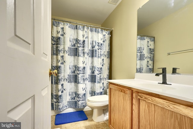 bathroom featuring tile patterned flooring, a shower with curtain, vanity, and toilet