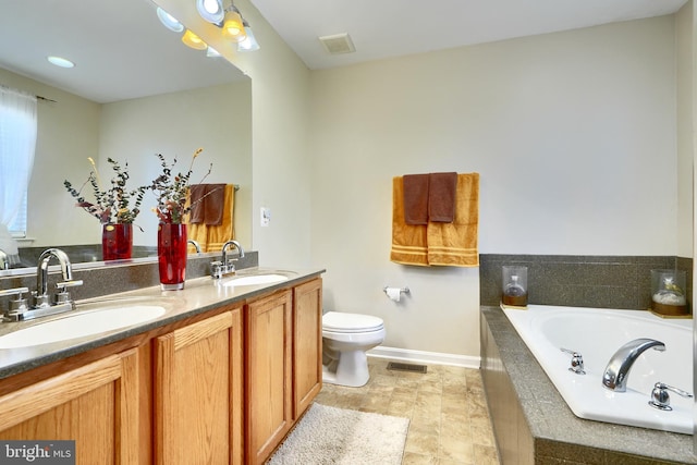 bathroom featuring vanity, toilet, and tiled tub