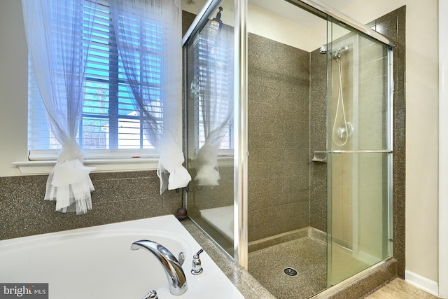 bathroom featuring independent shower and bath