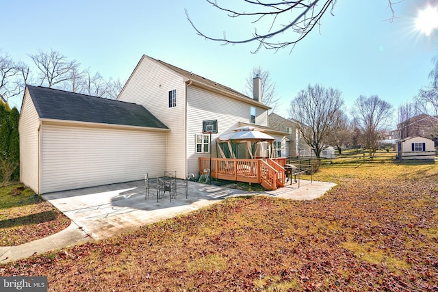 rear view of property featuring a gazebo, a deck, and a patio