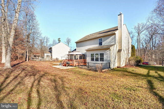 back of property featuring a gazebo, a lawn, and a deck