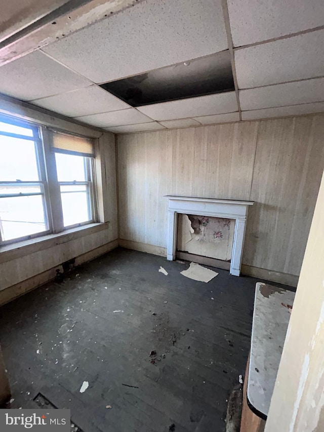 unfurnished living room featuring a paneled ceiling