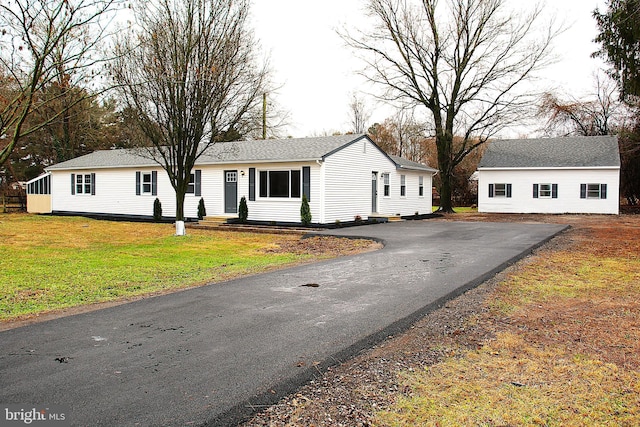 view of front facade featuring an outbuilding and a front yard