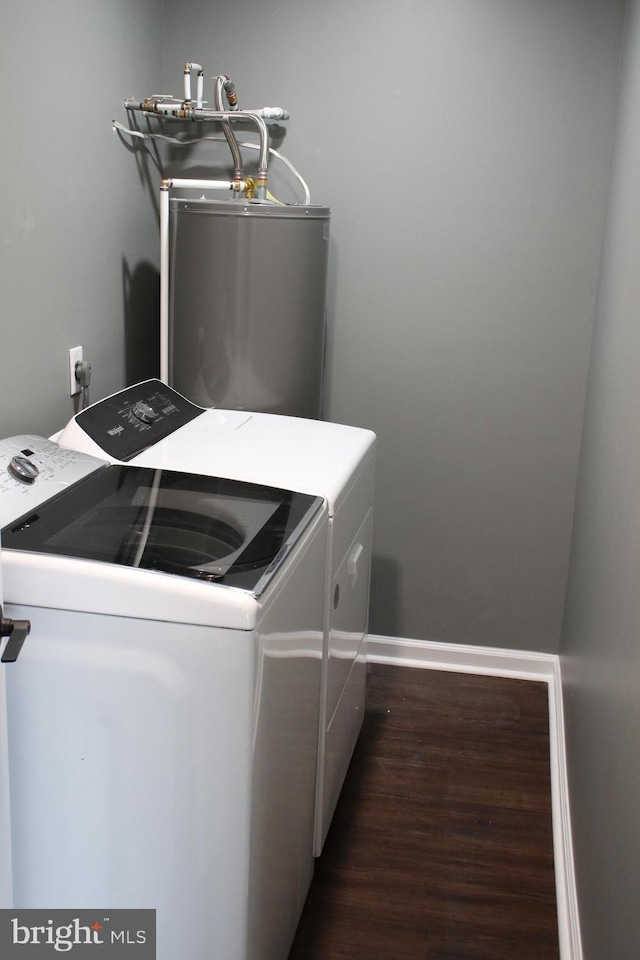 clothes washing area featuring washer and clothes dryer, dark wood-type flooring, and water heater