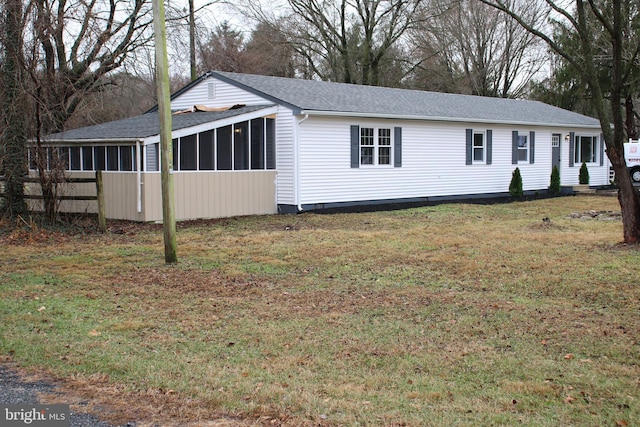 view of home's exterior with a sunroom and a yard