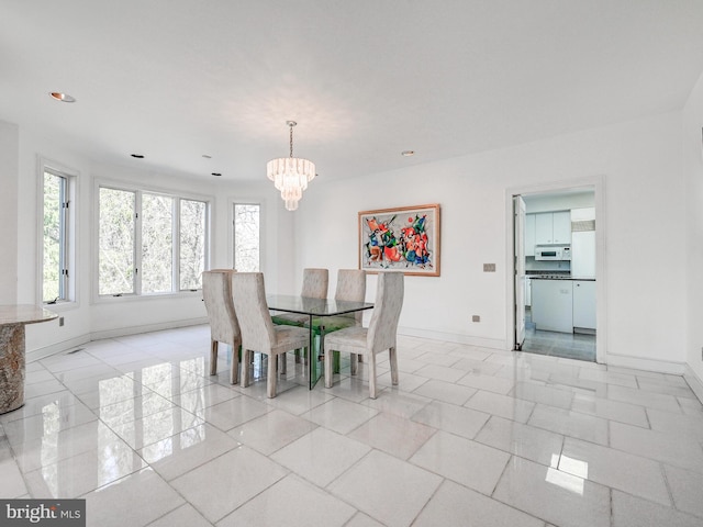 dining space with an inviting chandelier and baseboards