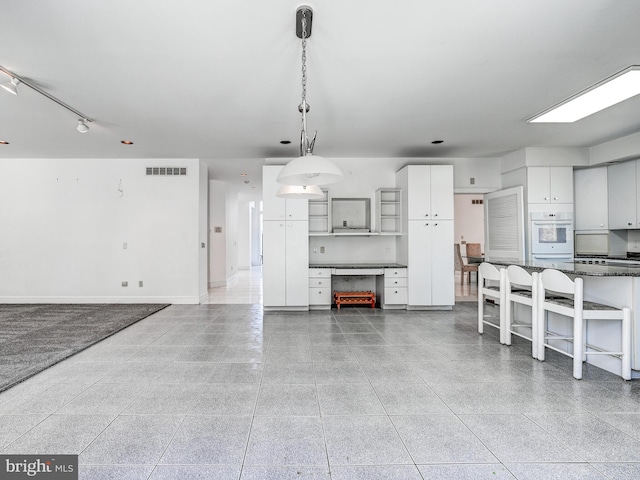 unfurnished dining area with baseboards and visible vents