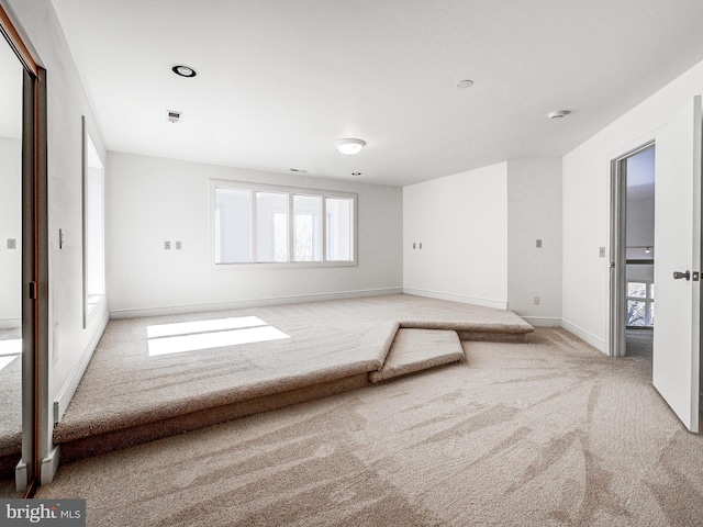 carpeted spare room with visible vents and baseboards