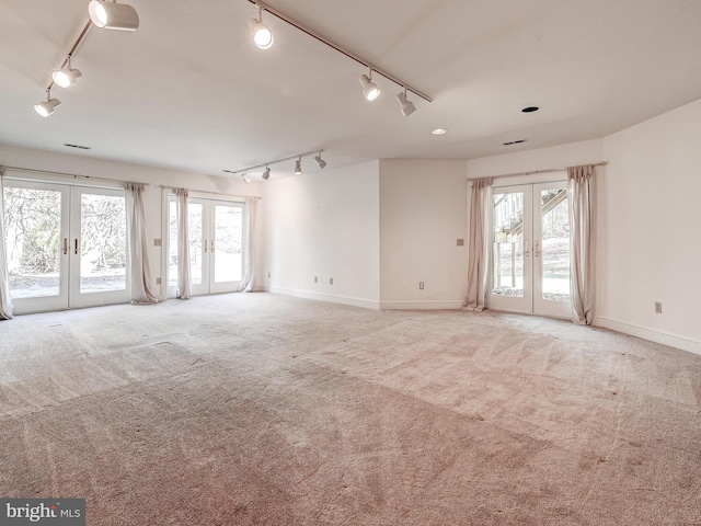 spare room featuring a healthy amount of sunlight, carpet flooring, and french doors