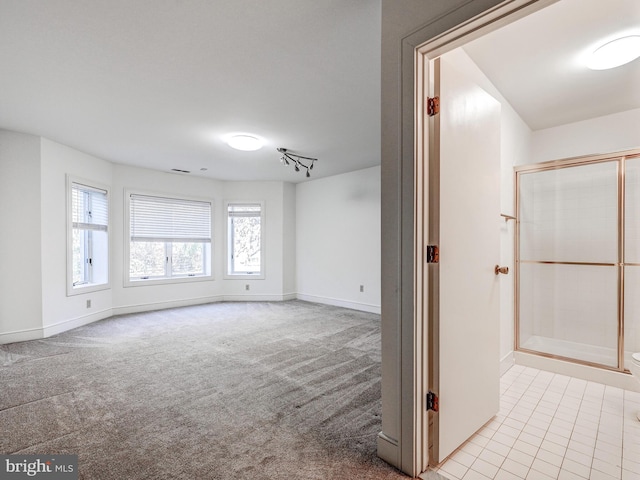 unfurnished living room featuring baseboards and carpet flooring