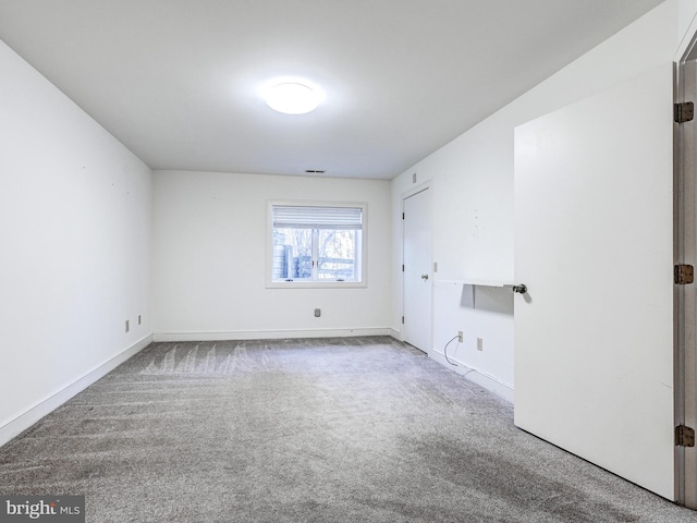 spare room featuring carpet, visible vents, and baseboards