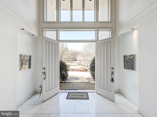 entryway with baseboards and a high ceiling