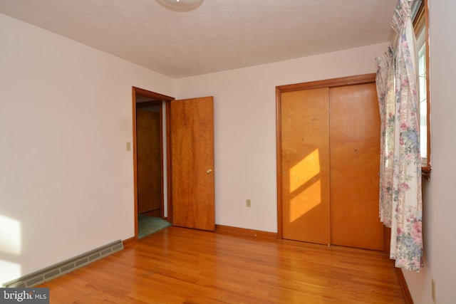 unfurnished bedroom with light wood-type flooring and a closet