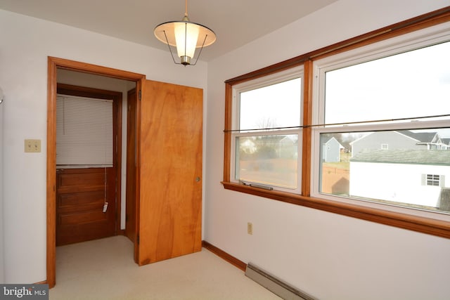 unfurnished bedroom with light carpet and a baseboard heating unit