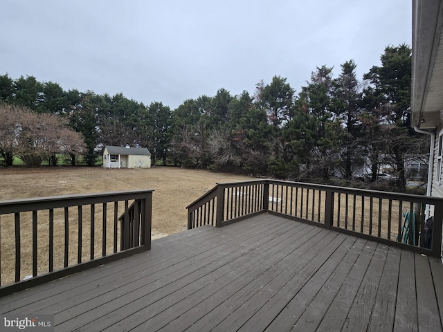 wooden terrace with a lawn and a storage shed