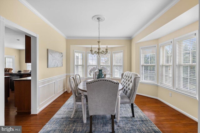 dining room featuring ornamental molding, dark hardwood / wood-style floors, and a notable chandelier