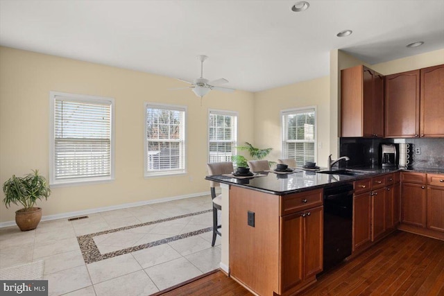 kitchen with dishwasher, sink, light tile patterned floors, ceiling fan, and kitchen peninsula