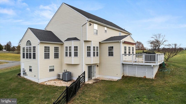 back of house with a lawn, a deck, and central air condition unit