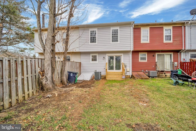 back of house featuring central air condition unit and a yard