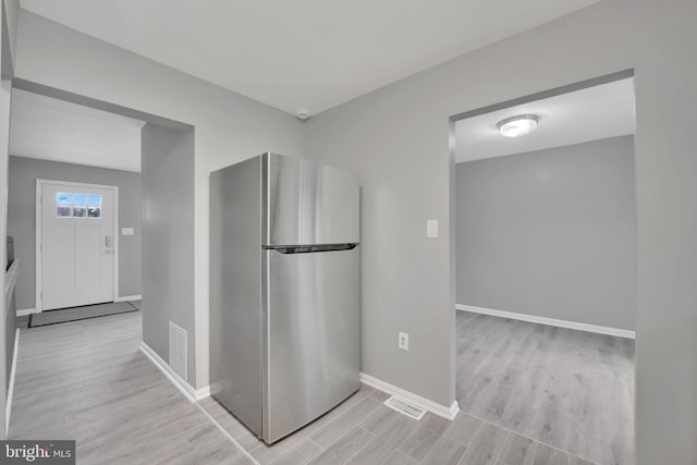 kitchen with light hardwood / wood-style floors and stainless steel refrigerator