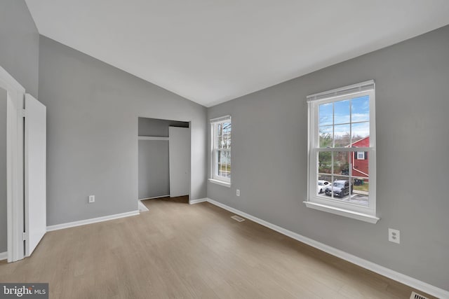 unfurnished bedroom featuring light hardwood / wood-style flooring and vaulted ceiling