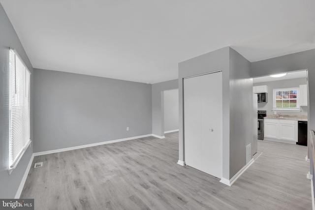 unfurnished room with sink and light wood-type flooring