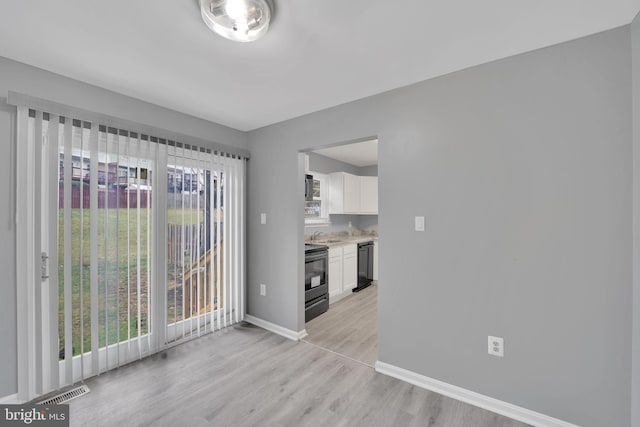 empty room featuring sink and light hardwood / wood-style floors