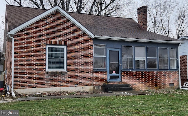 view of front of house featuring a sunroom and a front lawn