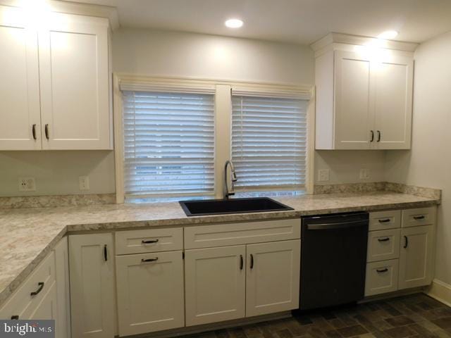 kitchen with white cabinetry, dishwasher, light stone counters, and sink