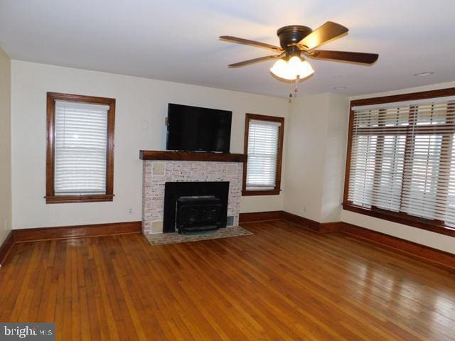 unfurnished living room featuring a fireplace, hardwood / wood-style flooring, and ceiling fan