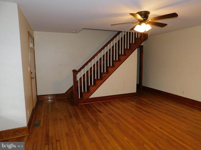 interior space with ceiling fan and dark hardwood / wood-style flooring