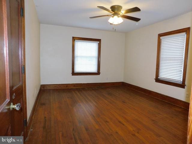 spare room featuring ceiling fan and dark hardwood / wood-style flooring