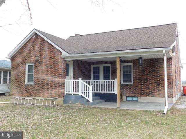 view of front of home with a porch, a front lawn, and a patio area