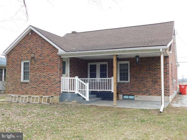 view of front of house with covered porch and a front lawn