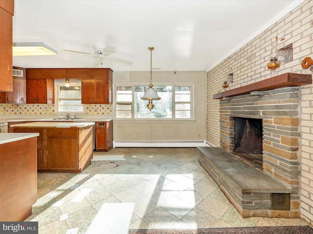 kitchen featuring pendant lighting, a baseboard heating unit, decorative backsplash, a fireplace, and brick wall