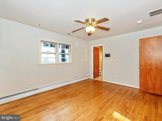 spare room with ceiling fan, baseboard heating, and light hardwood / wood-style flooring