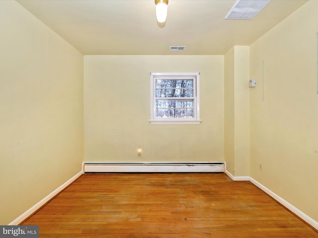 empty room featuring light hardwood / wood-style floors and a baseboard heating unit