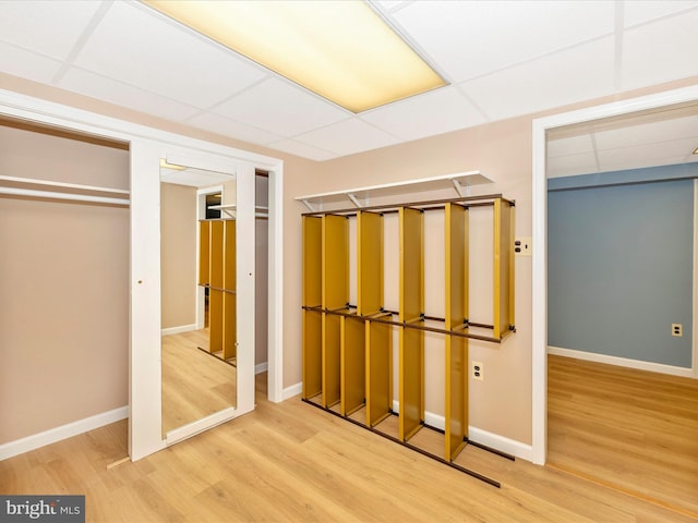 unfurnished bedroom with a paneled ceiling, a closet, and wood-type flooring