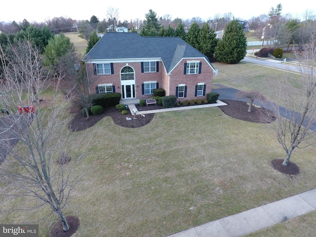 colonial inspired home with a front lawn