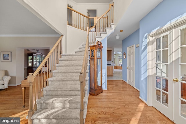 staircase with hardwood / wood-style flooring and crown molding