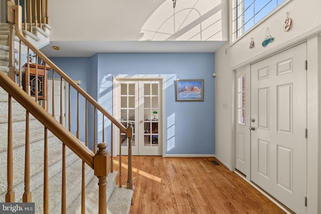 foyer entrance with french doors and light hardwood / wood-style floors