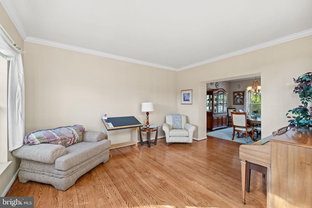 living area featuring hardwood / wood-style floors, crown molding, and a chandelier