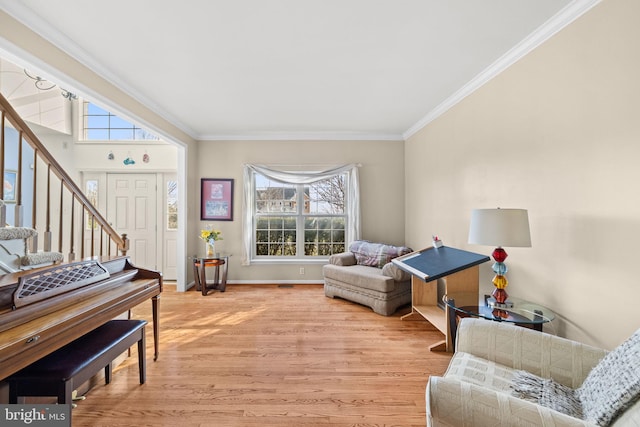 living area featuring light hardwood / wood-style floors, plenty of natural light, and ornamental molding