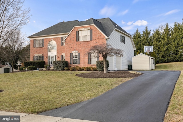 view of front of property featuring a garage, a front lawn, and an outdoor structure