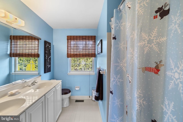 bathroom featuring vanity, a healthy amount of sunlight, toilet, and curtained shower